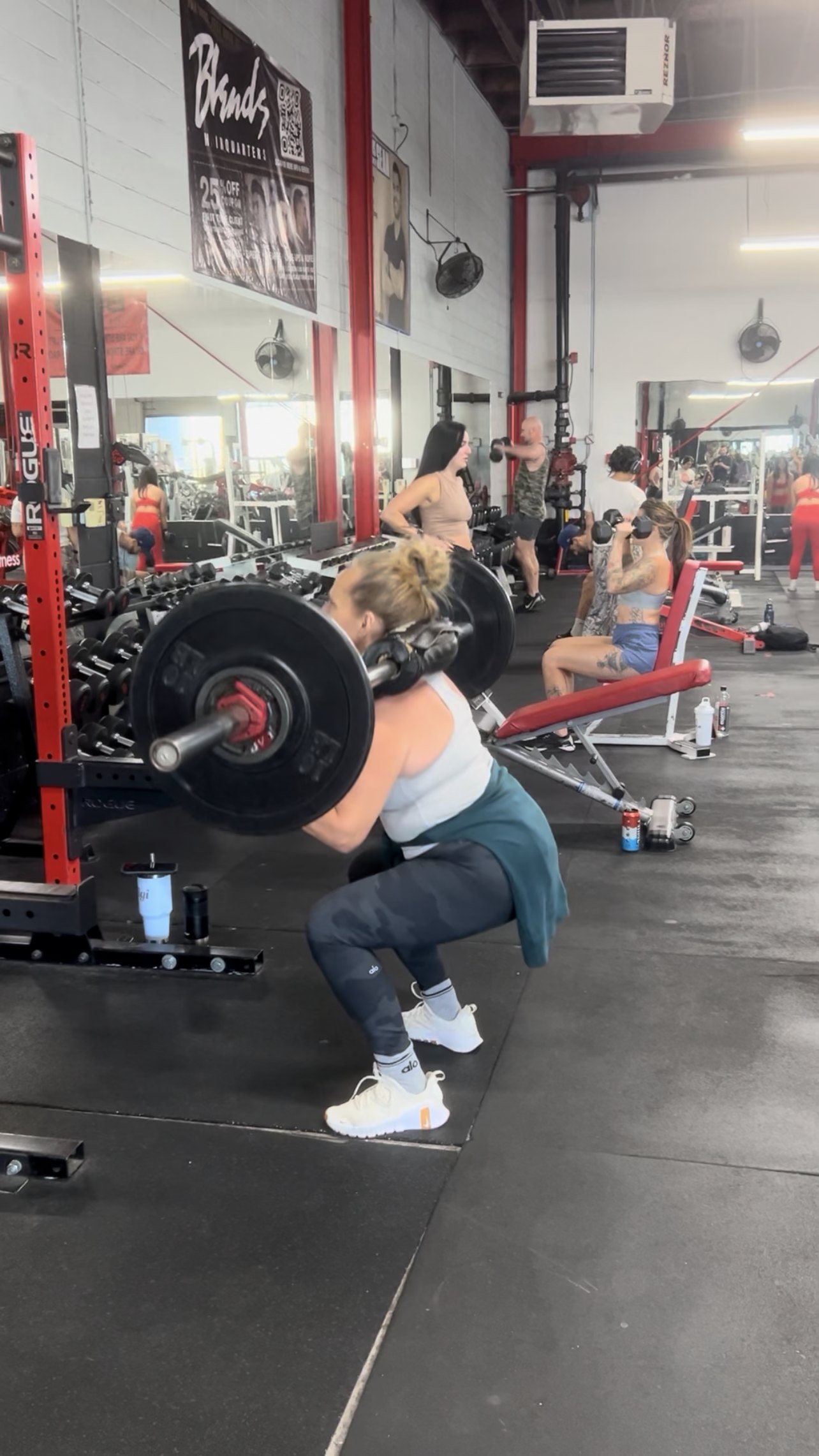 Gigi performing a loaded barbell back squat